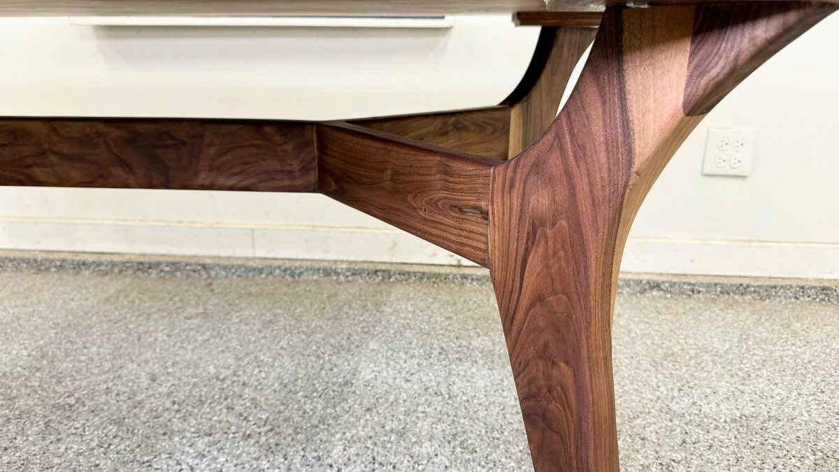 Close-up of a tapered walnut leg joining a table apron